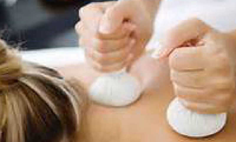 Woman having a Thai Hot Herbal Stem massage